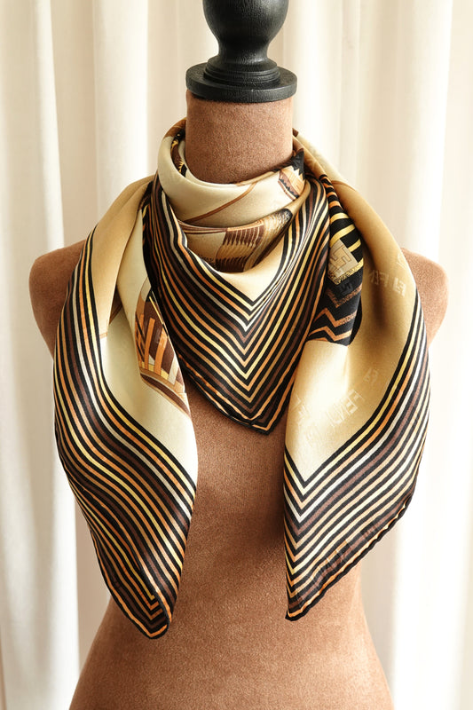 Fendi vintage silk scarf styled on mannequin: striped geometric border in cream, gold and black, tribal pottery vessel motif, circa 1990s