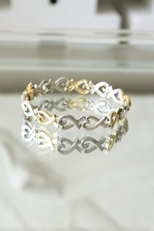 Paloma Picasso for Tiffany & Co. Loving Heart link bracelet: close-up detail of sterling silver and 18k gold heart-shaped links showing two-tone contrast and craftsmanship