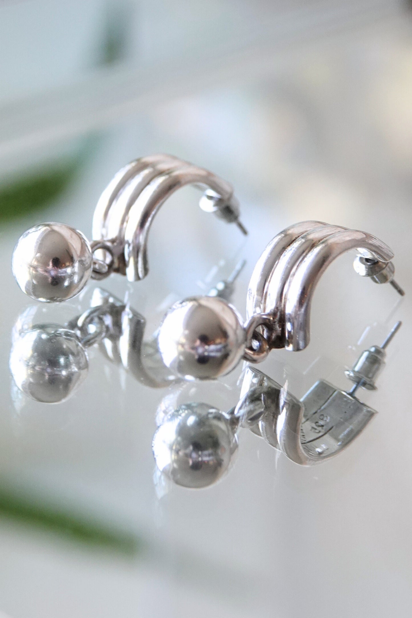 Mexican 925 silver earrings — angled view on glass
