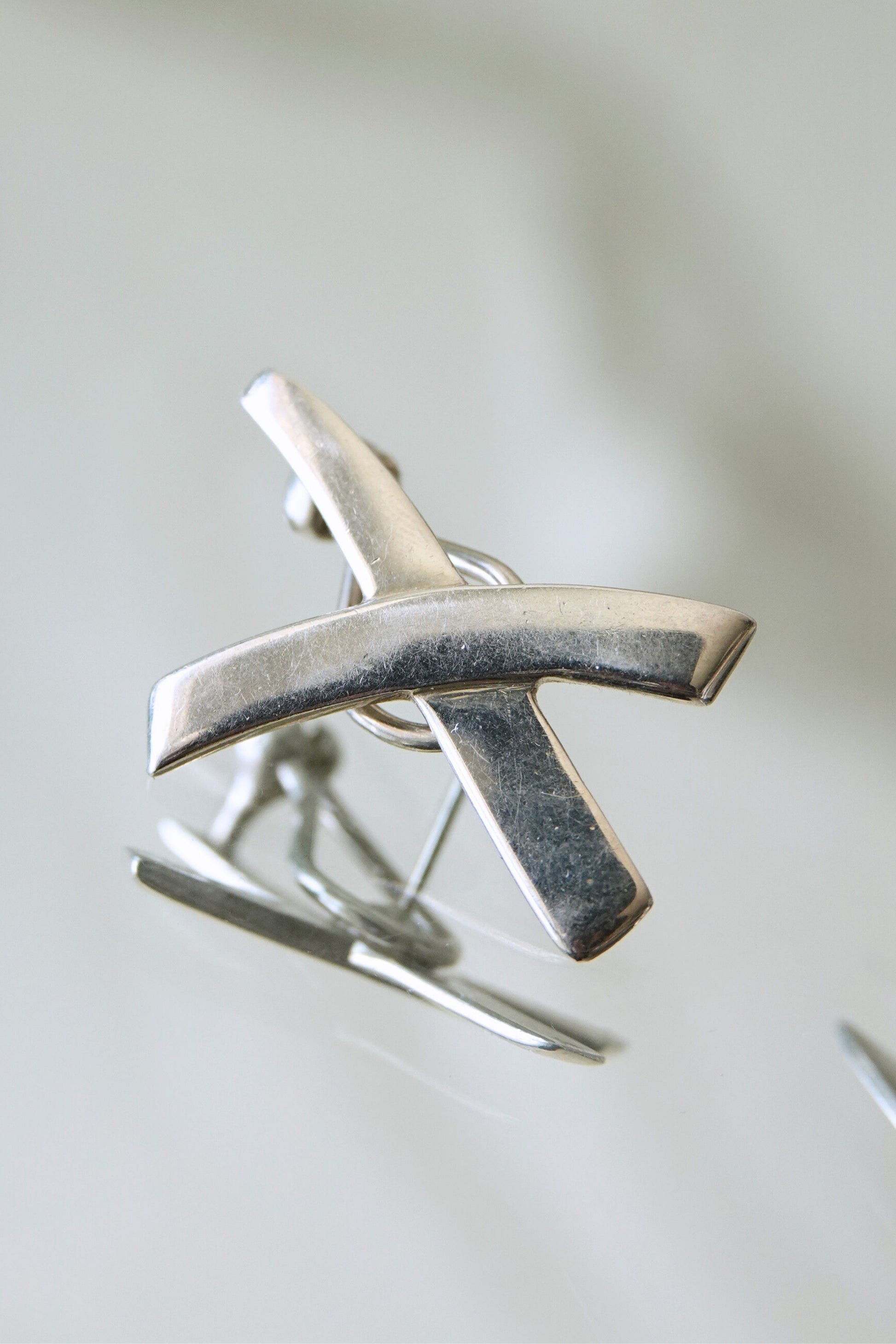 Vintage 1985 Paloma Picasso for Tiffany & Co. sterling silver Kiss X earrings: close-up macro detail of X motif surface texture and engraved Paloma Picasso signature