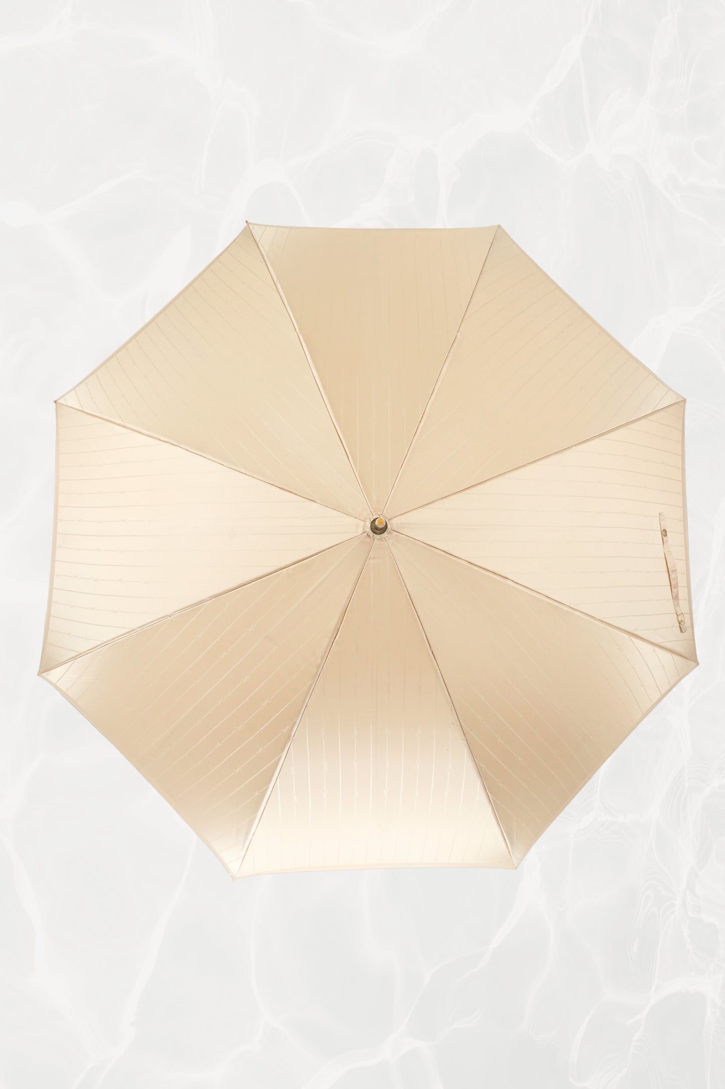 Vintage YSL Yves Saint Laurent gold umbrella: close-up of the embossed YSL monogram on the gold handle showing the crisp lettering and luxe finish