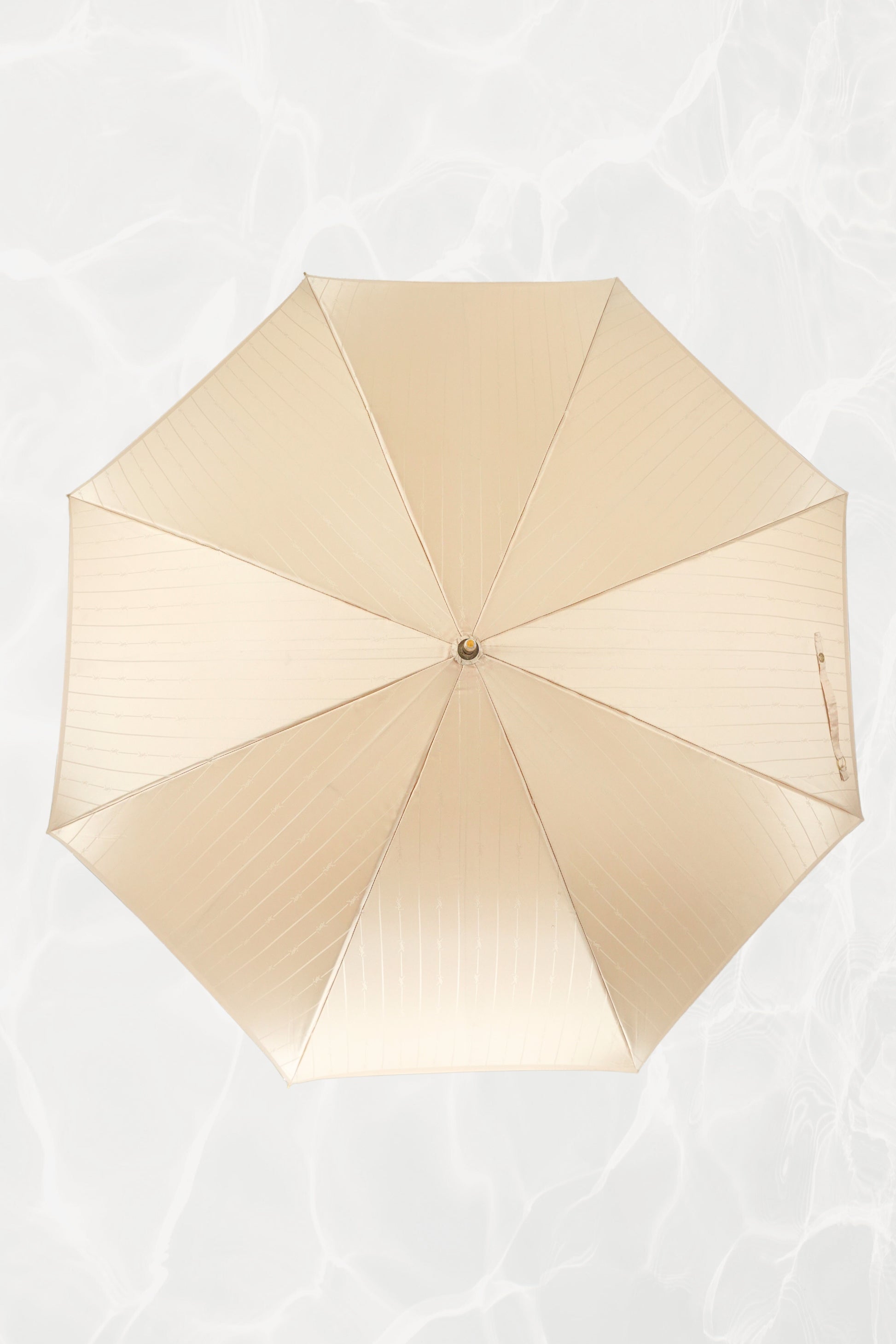 Vintage YSL Yves Saint Laurent gold umbrella: close-up of the embossed YSL monogram on the gold handle showing the crisp lettering and luxe finish