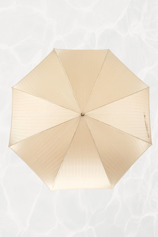 Vintage YSL Yves Saint Laurent gold umbrella: close-up of the embossed YSL monogram on the gold handle showing the crisp lettering and luxe finish