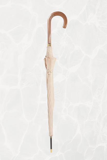 Vintage YSL Yves Saint Laurent gold umbrella: angled view of the handle showing the embossed YSL monogram from a different perspective against the canopy