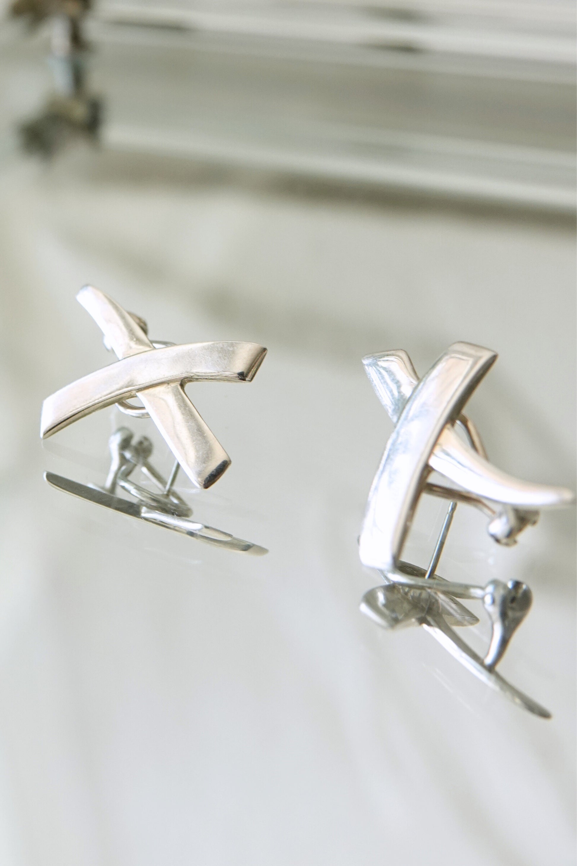 Vintage 1985 Paloma Picasso for Tiffany & Co. sterling silver Kiss X earrings: angled view of earring pair highlighting the bold geometric X shape and high polish finish