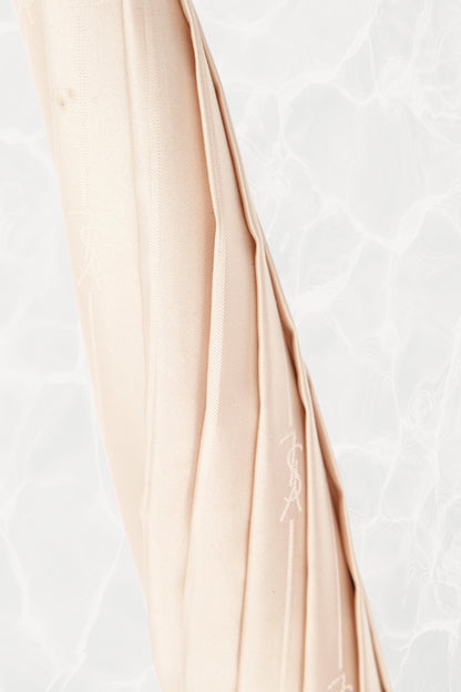 Vintage YSL Yves Saint Laurent gold umbrella: handle detail showing the curved hook shape and polished gold finish with the embossed monogram