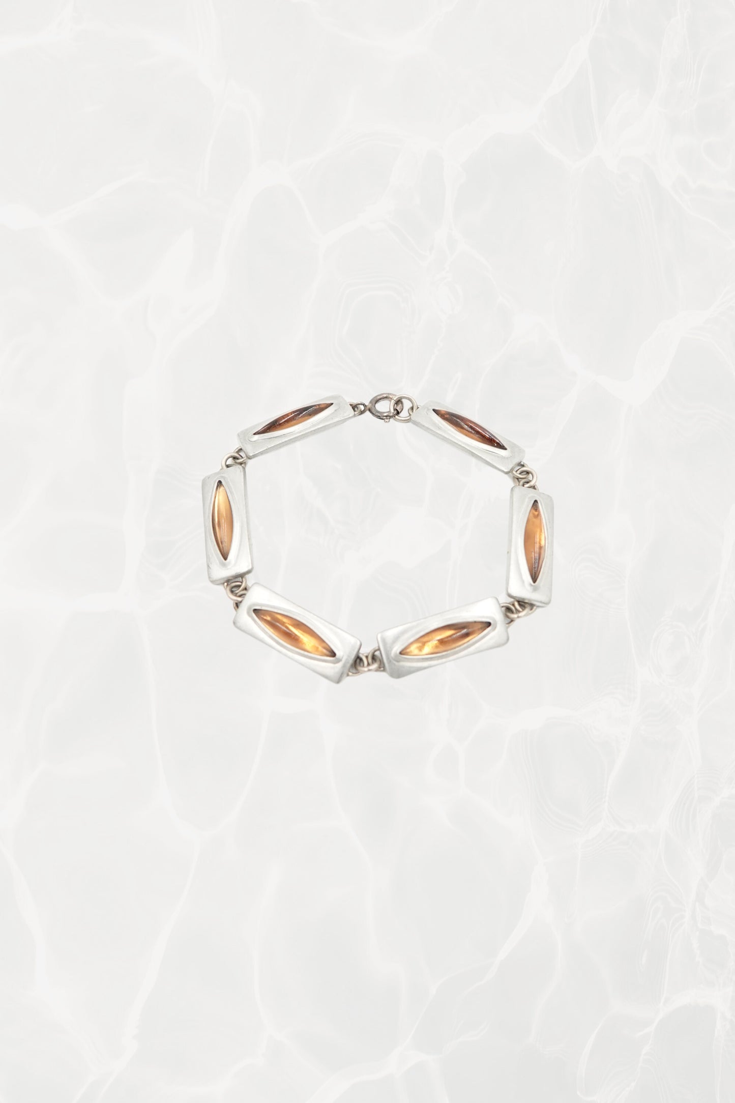 Jørgen Jensen pewter and amber glass link bracelet, Denmark — full piece coiled, pool background