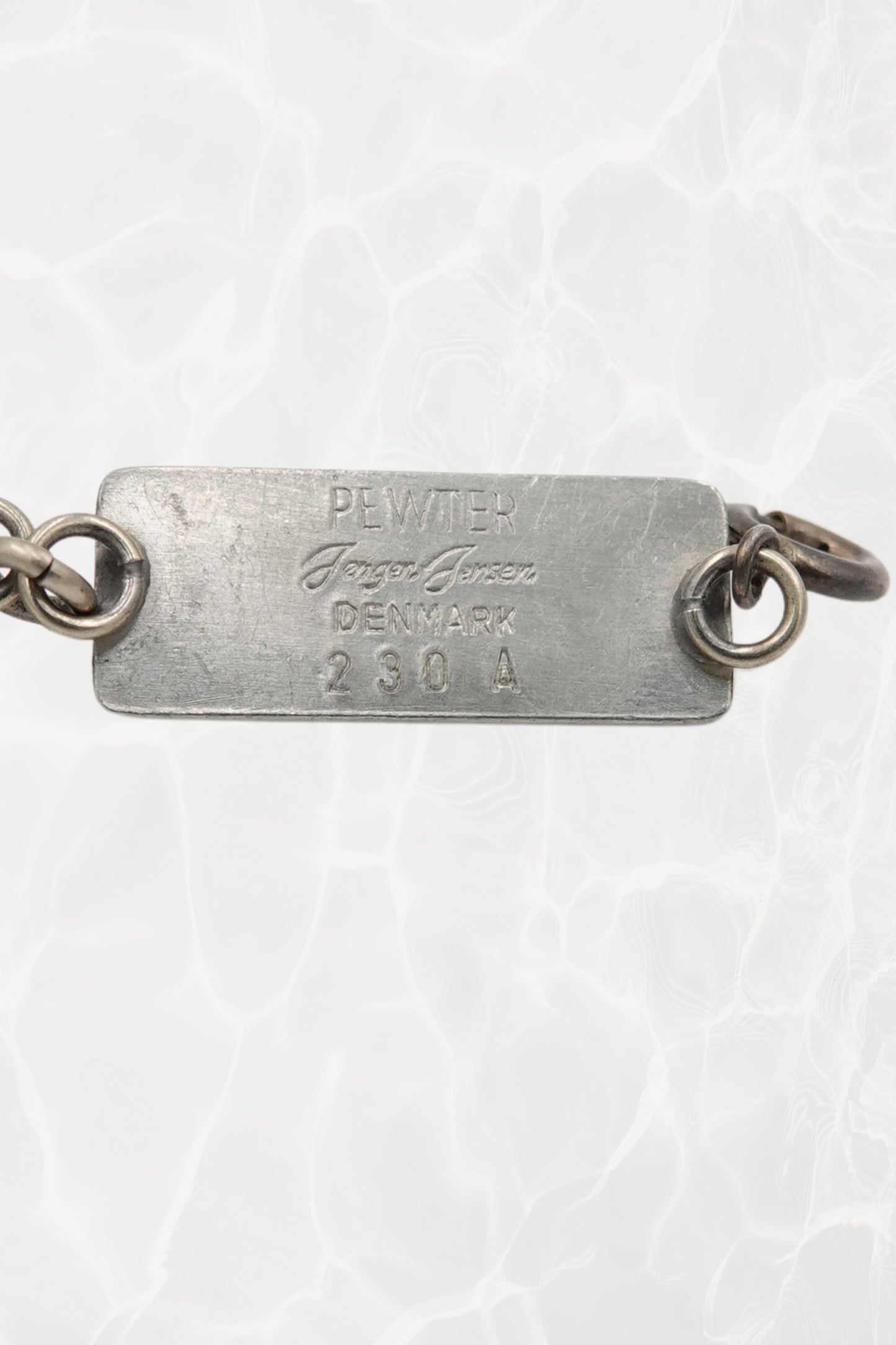 Jørgen Jensen pewter bracelet — reverse view showing stamped tag: PEWTER / Jørgen Jensen / DENMARK / 230 A