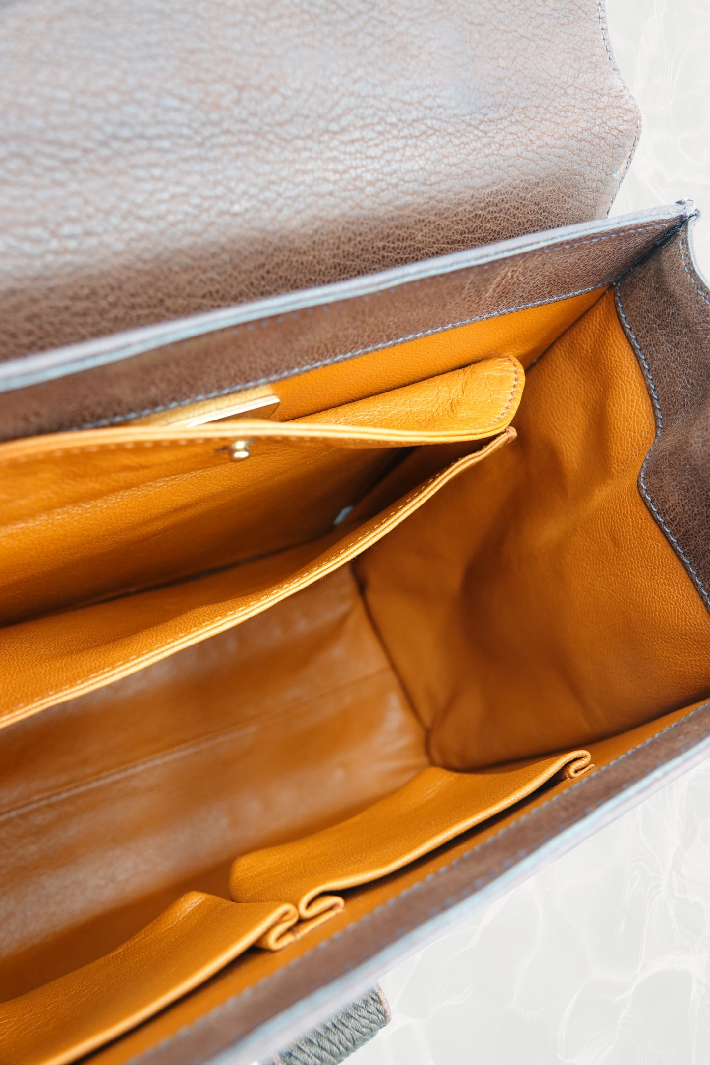 Flat lay of vintage Prada Antic Passamane brown bag with top handles