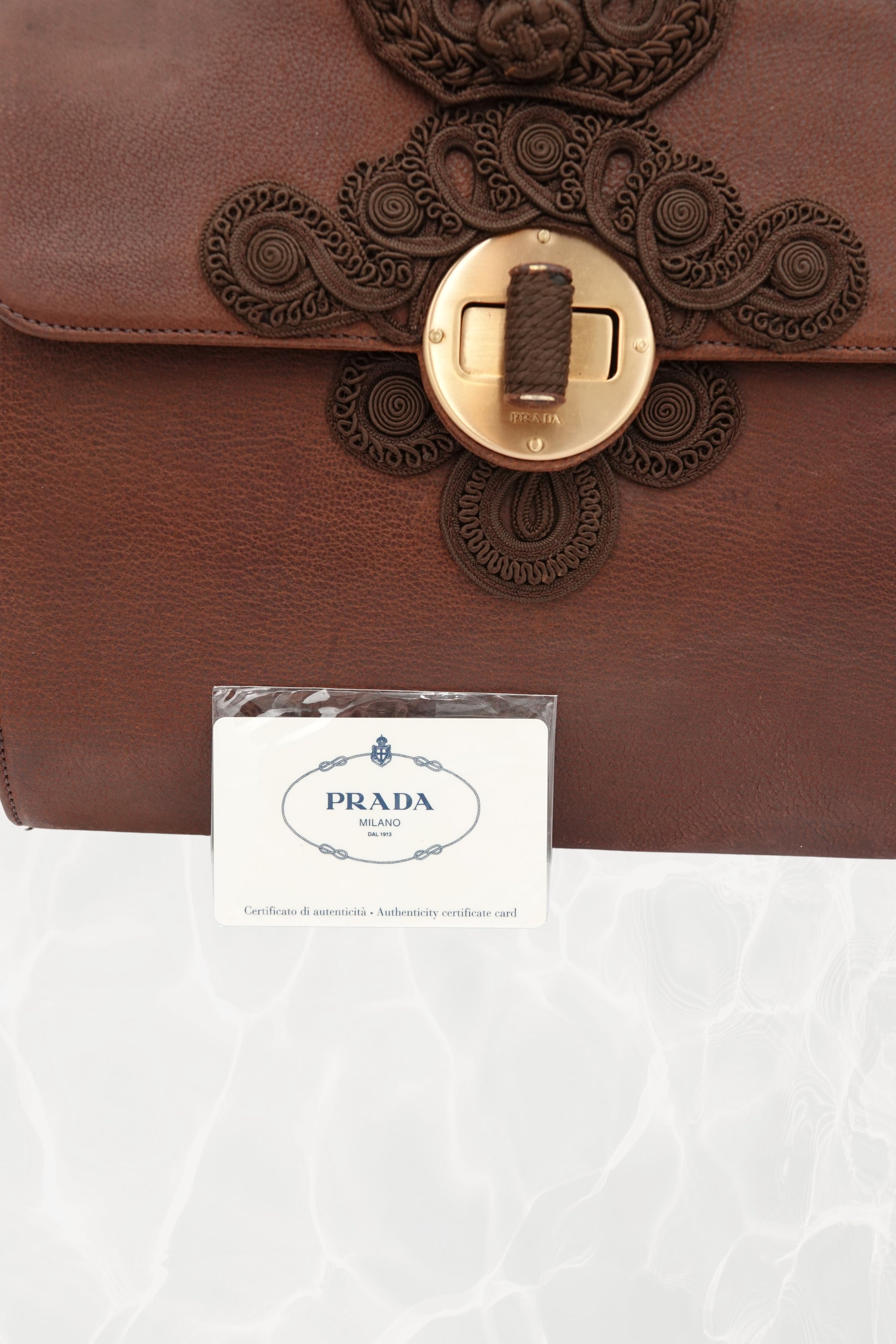 Close-up texture detail of brown goat leather on vintage Prada Antic Passamane bag