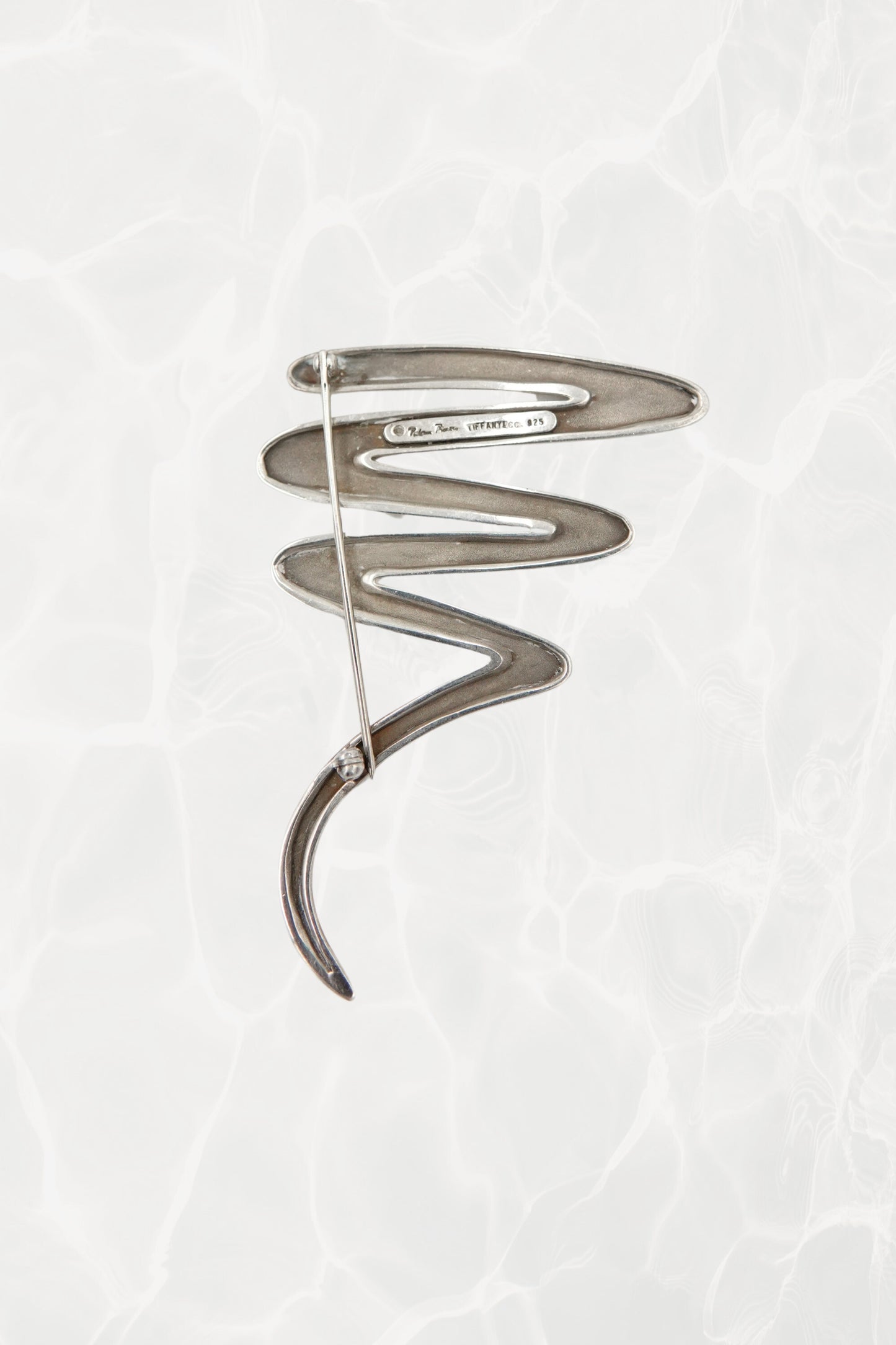 Vintage Paloma Picasso sterling silver Scribble brooch: angled view showing the dimensional depth of the abstract scribble and the pin closure mechanism on the back