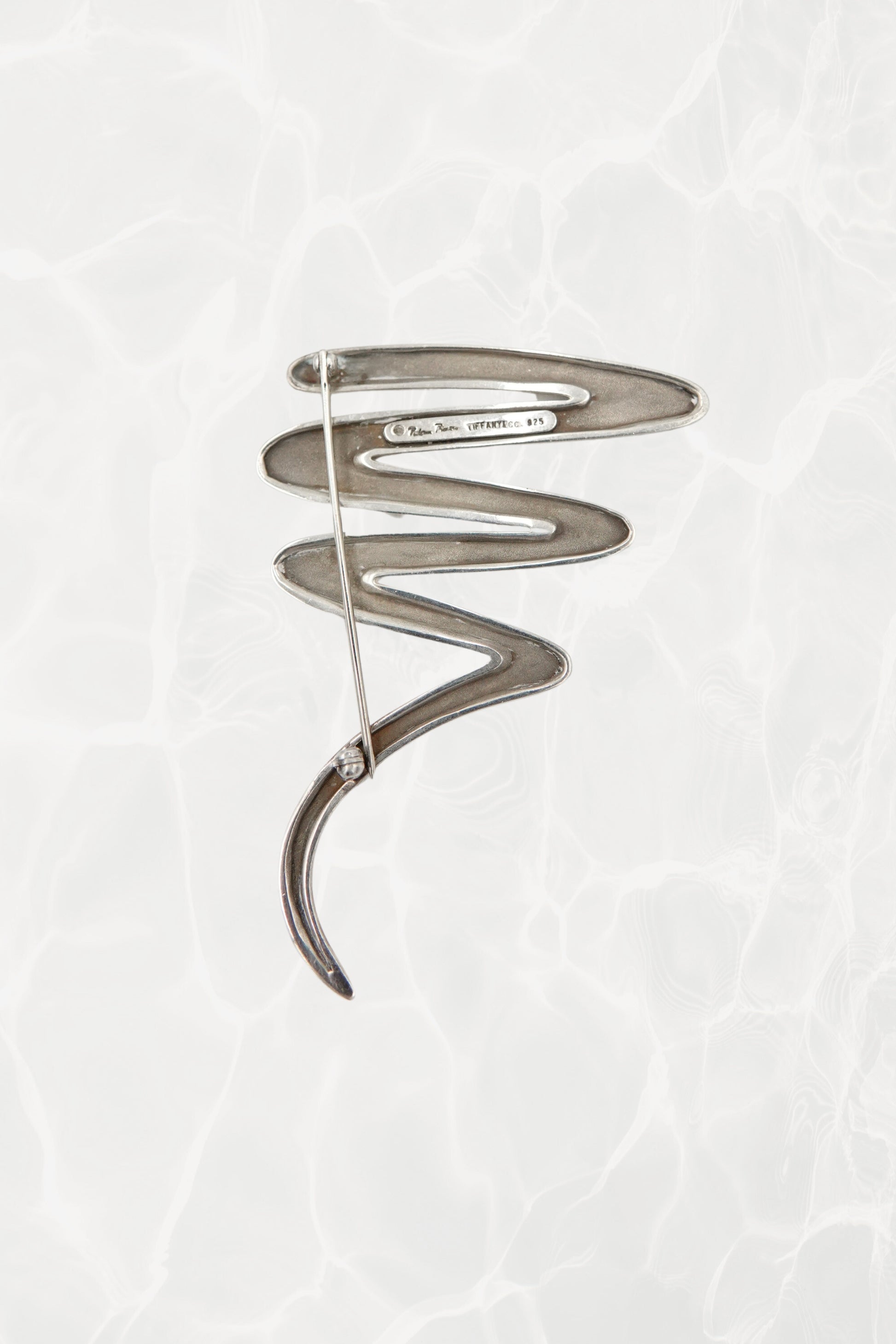 Vintage Paloma Picasso sterling silver Scribble brooch: angled view showing the dimensional depth of the abstract scribble and the pin closure mechanism on the back