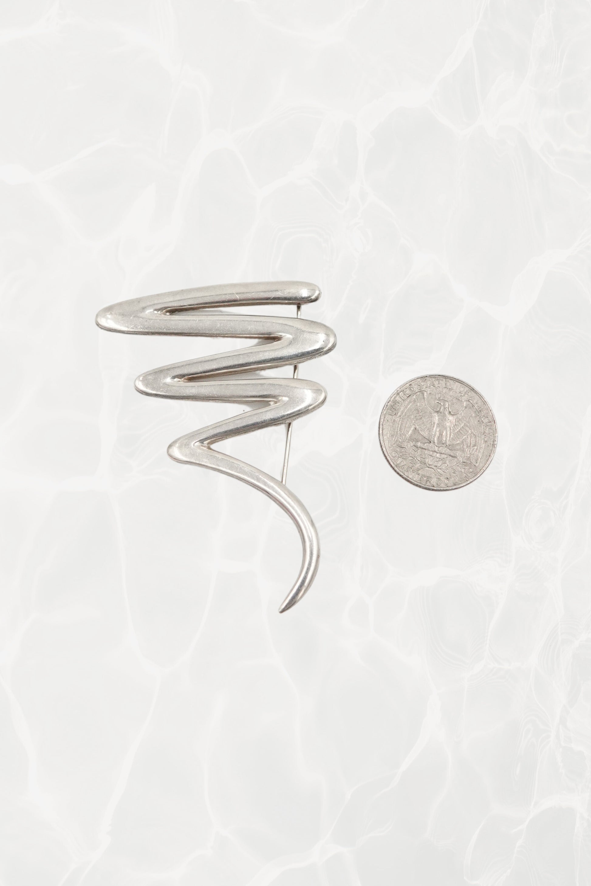 Vintage Paloma Picasso sterling silver Scribble brooch: reverse side view showing the pin stem, safety clasp, and Paloma Picasso signature hallmark on the back
