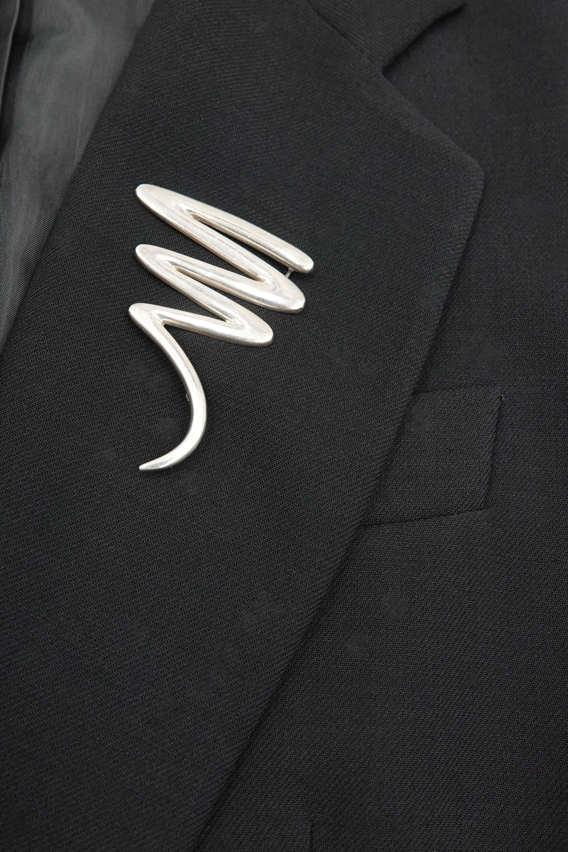 Vintage Paloma Picasso sterling silver Scribble brooch: close-up detail of the fluid abstract scribble motif showing the sculptural wire-like silver form