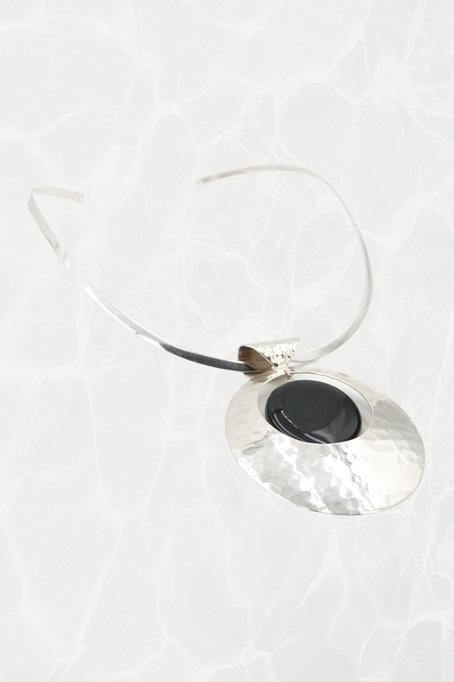 Sterling silver disc pendant and neck cuff, angled view