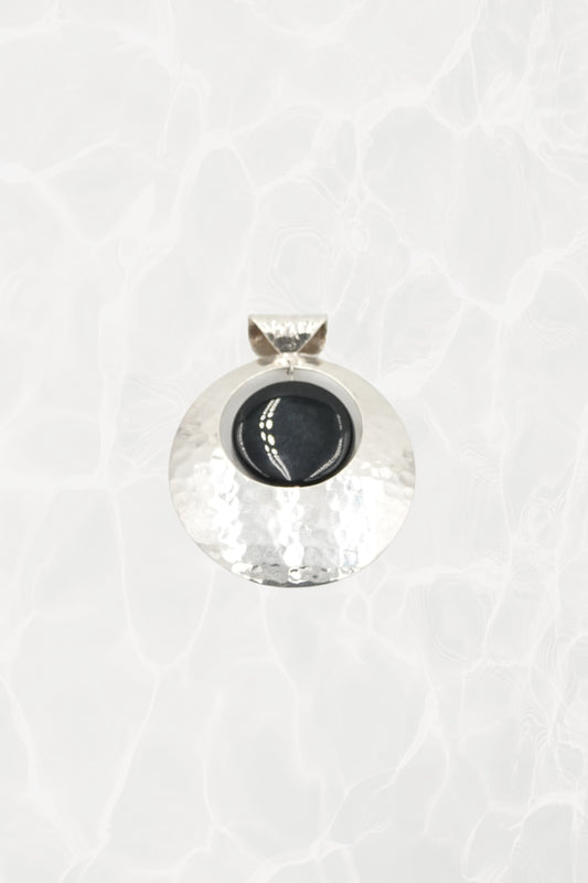 Hammered sterling silver disc pendant with black onyx cabochon, white background