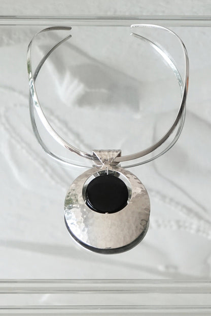 SilverSue neck cuff and pendant styled together on glass