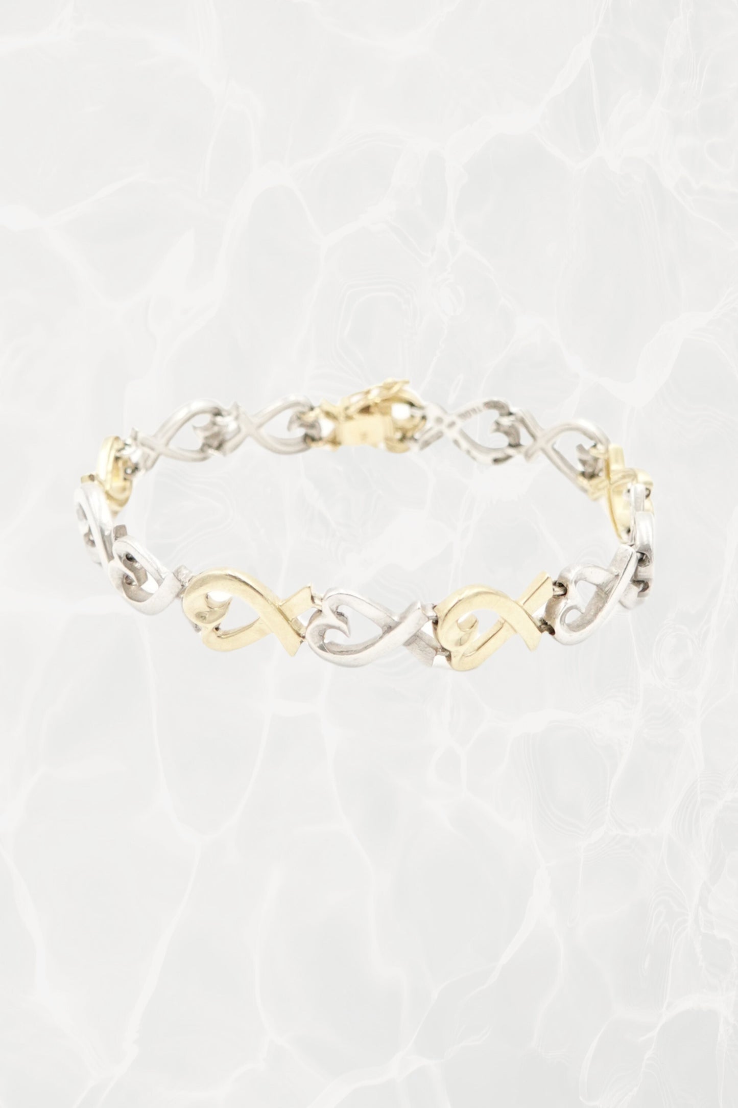 Paloma Picasso for Tiffany & Co. Loving Heart link bracelet in sterling silver and 18k gold: front view showing full bracelet with heart-shaped links against neutral background