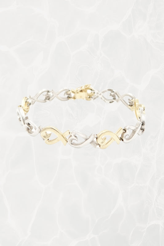 Paloma Picasso for Tiffany & Co. Loving Heart link bracelet in sterling silver and 18k gold: front view showing full bracelet with heart-shaped links against neutral background