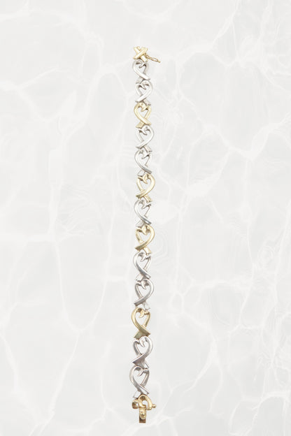 Paloma Picasso for Tiffany & Co. Loving Heart link bracelet: worn on wrist view showing scale, drape and elegance of the sterling silver and 18k gold heart link design