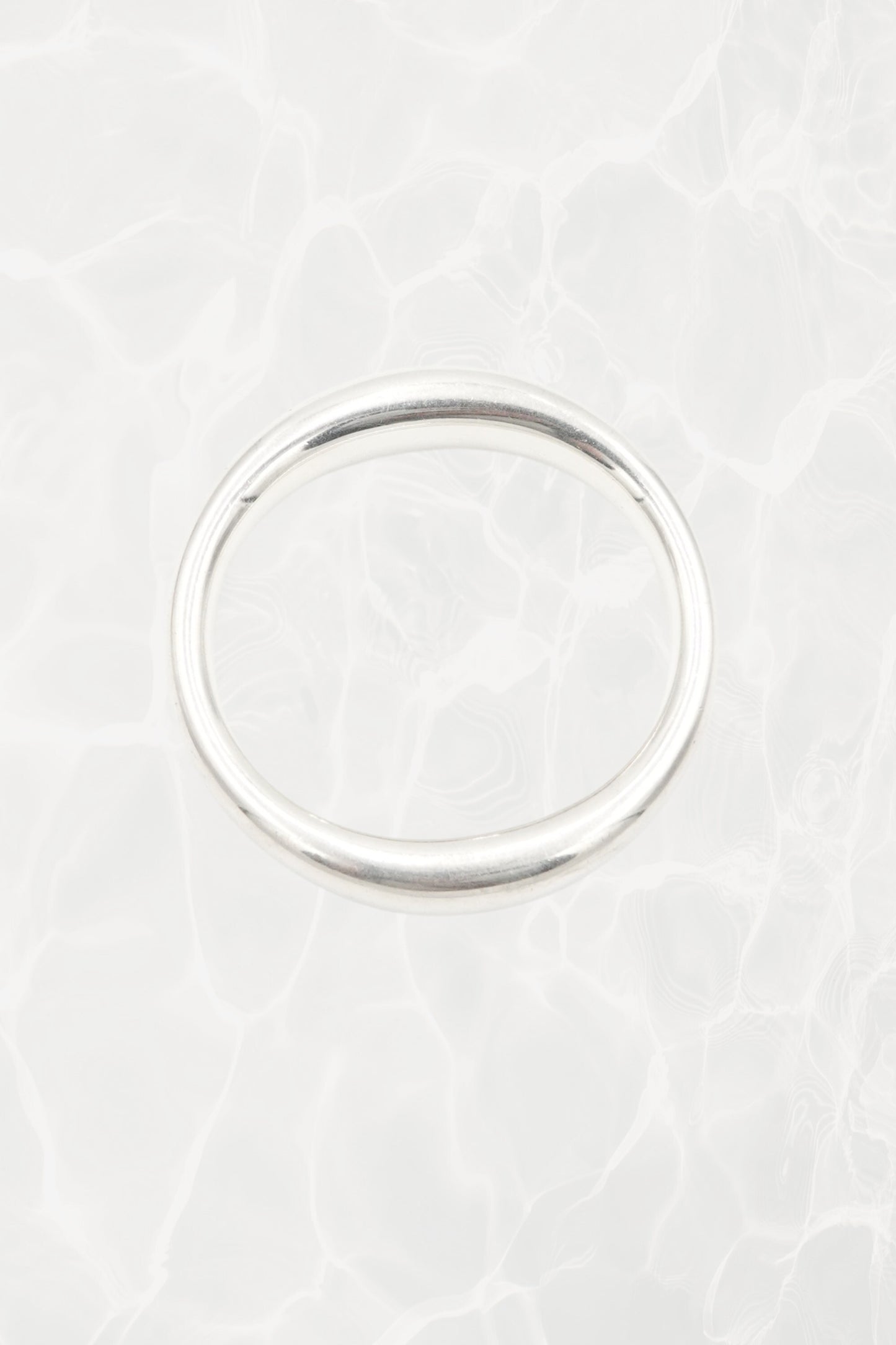 Elsa Peretti for Tiffany & Co. sculptural sterling silver closed bangle front view: smooth organic oval form with characteristic sculptural silhouette, Tiffany hallmark visible