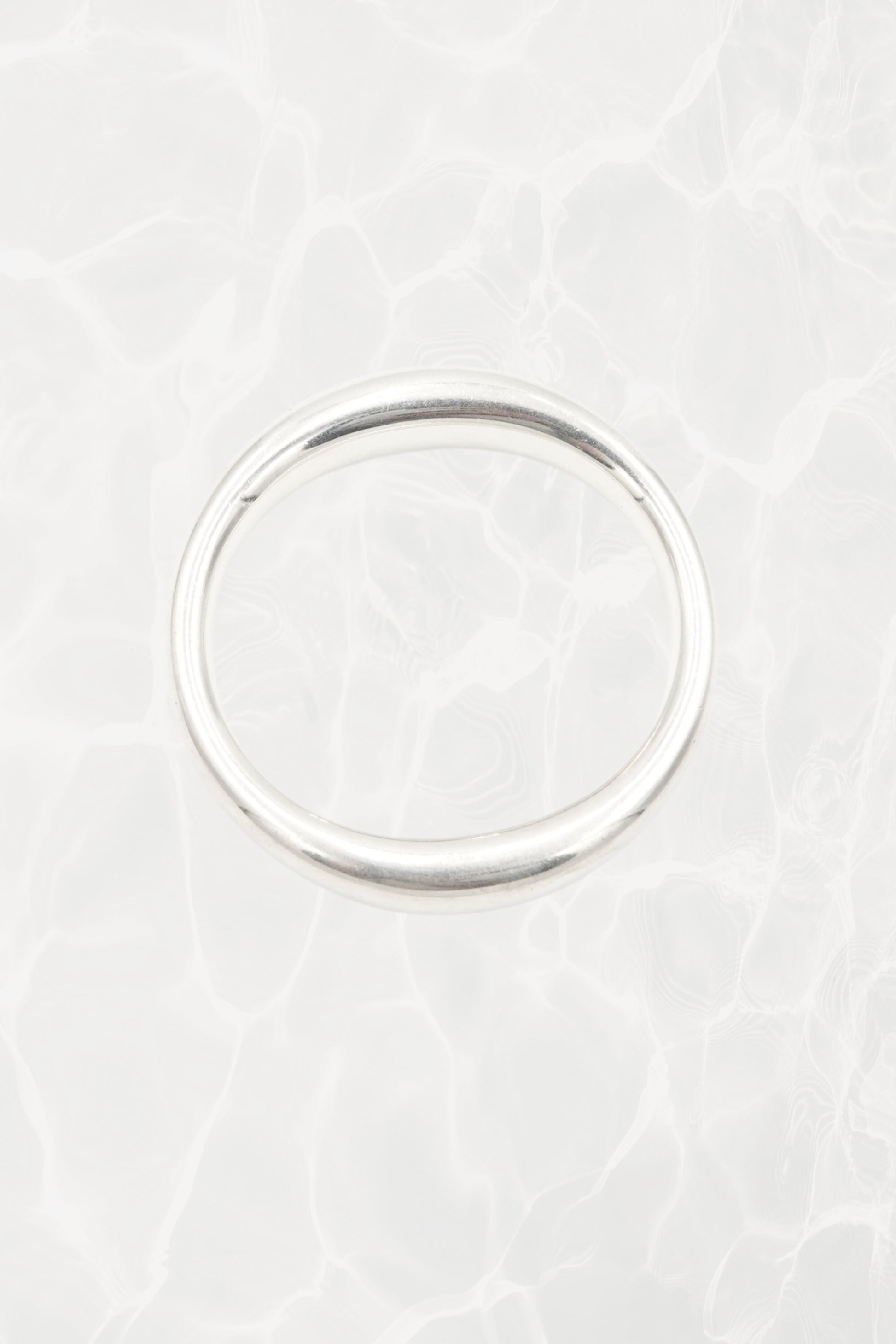 Elsa Peretti for Tiffany & Co. sculptural sterling silver closed bangle front view: smooth organic oval form with characteristic sculptural silhouette, Tiffany hallmark visible