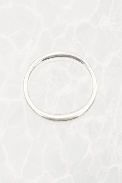 Elsa Peretti for Tiffany & Co. sculptural sterling silver closed bangle front view: smooth organic oval form with characteristic sculptural silhouette, Tiffany hallmark visible