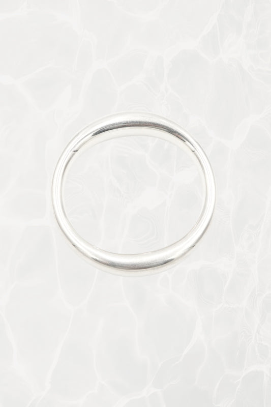 Elsa Peretti for Tiffany & Co. sculptural sterling silver closed bangle front view: smooth organic oval form with characteristic sculptural silhouette, Tiffany hallmark visible