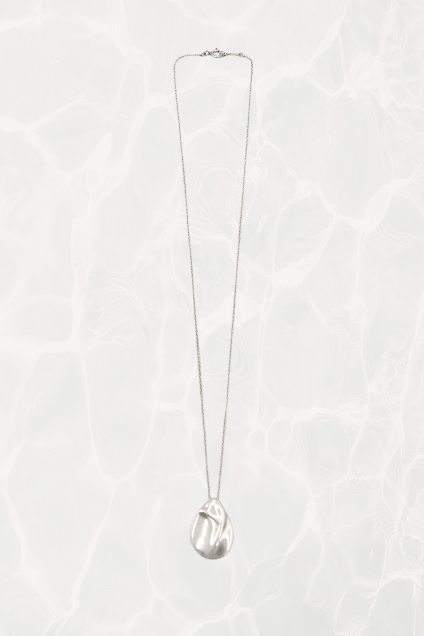 Elsa Peretti for Tiffany & Co. sterling silver Madonna pendant necklace: angled view showing pendant drop and chain length against neutral background