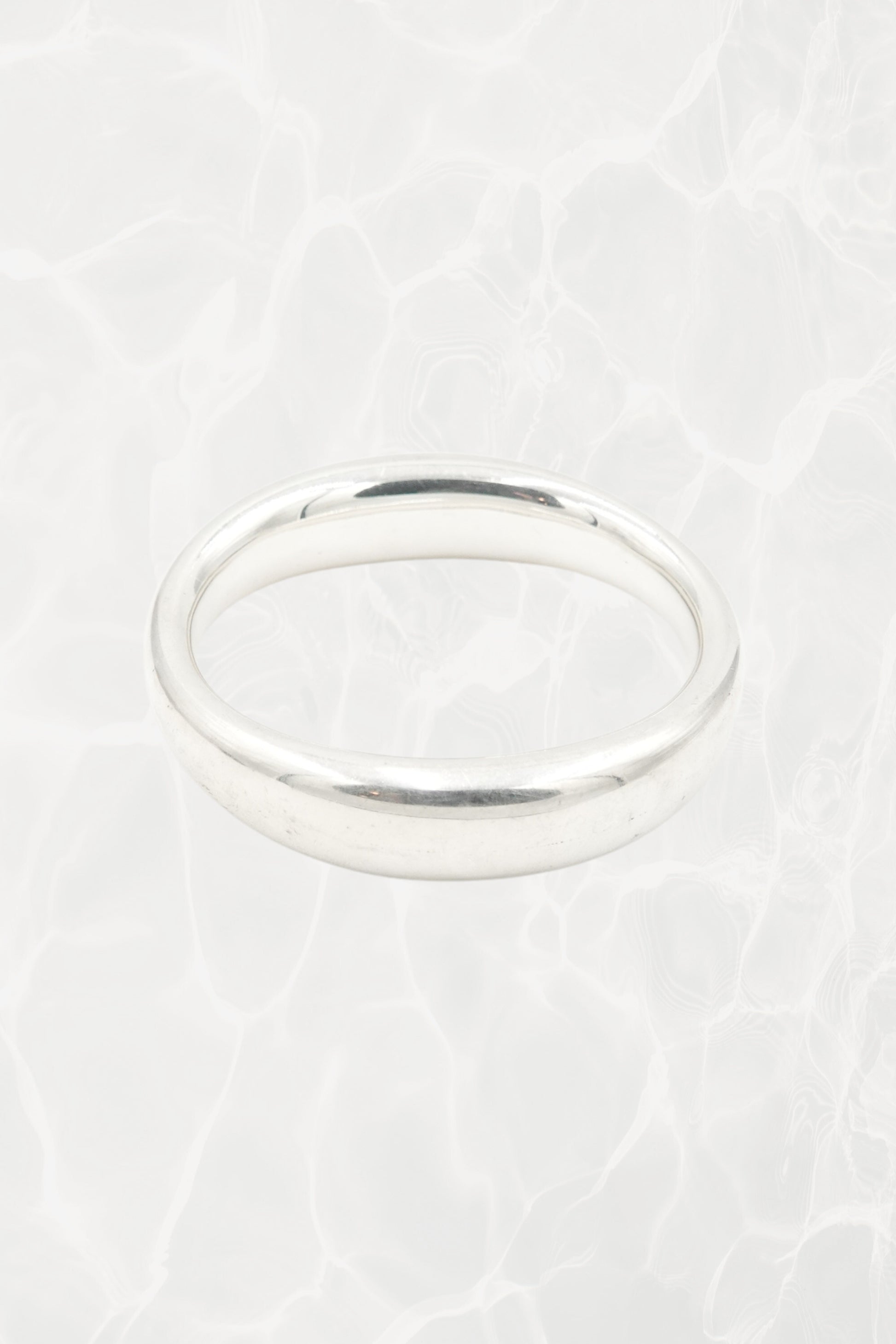 Elsa Peretti for Tiffany & Co. sculptural sterling silver closed bangle overhead view: top-down perspective of smooth oval closed form showing even width and polish of sterling silver