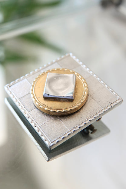 Vintage square brooch Paris — front on glass surface