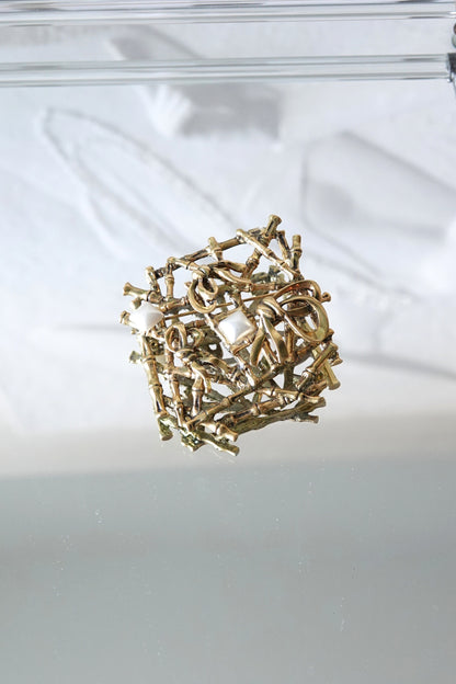 Sculptural bamboo brooch — three-quarter view on glass