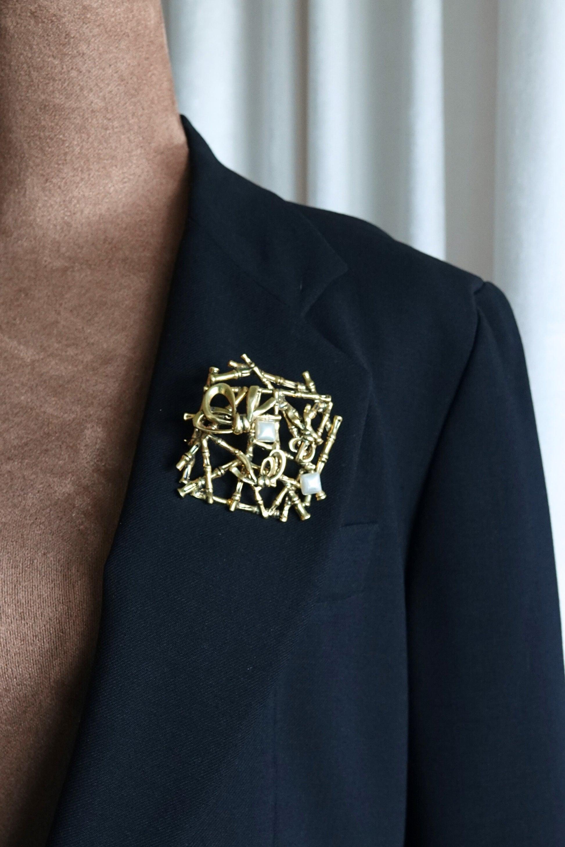 Gold-tone bamboo brooch — angled view on glass surface