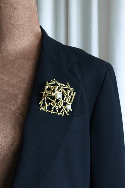 Gold-tone bamboo brooch — angled view on glass surface