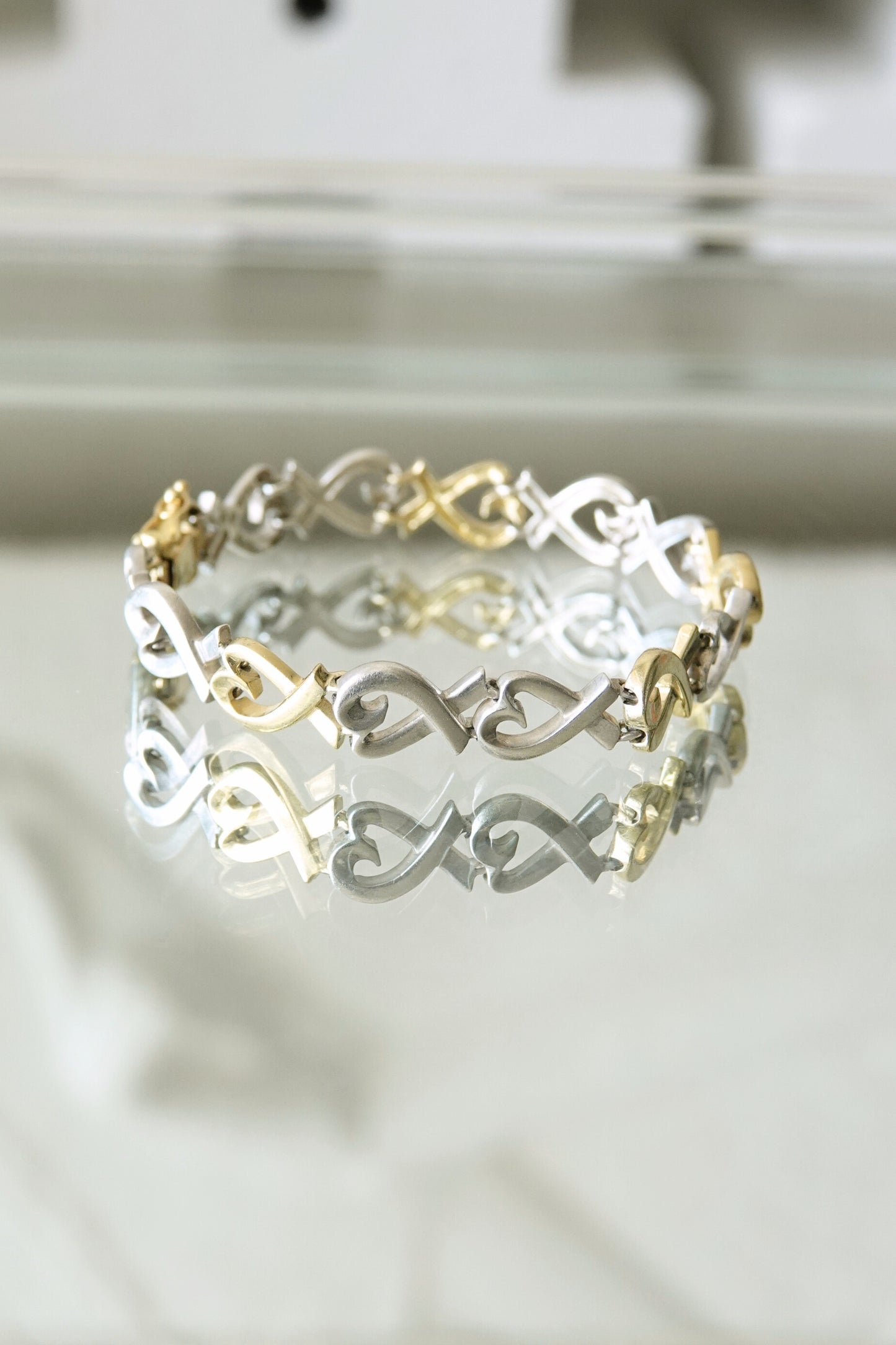 Paloma Picasso for Tiffany & Co. Loving Heart link bracelet: close-up detail of sterling silver and 18k gold heart-shaped links showing two-tone contrast and craftsmanship