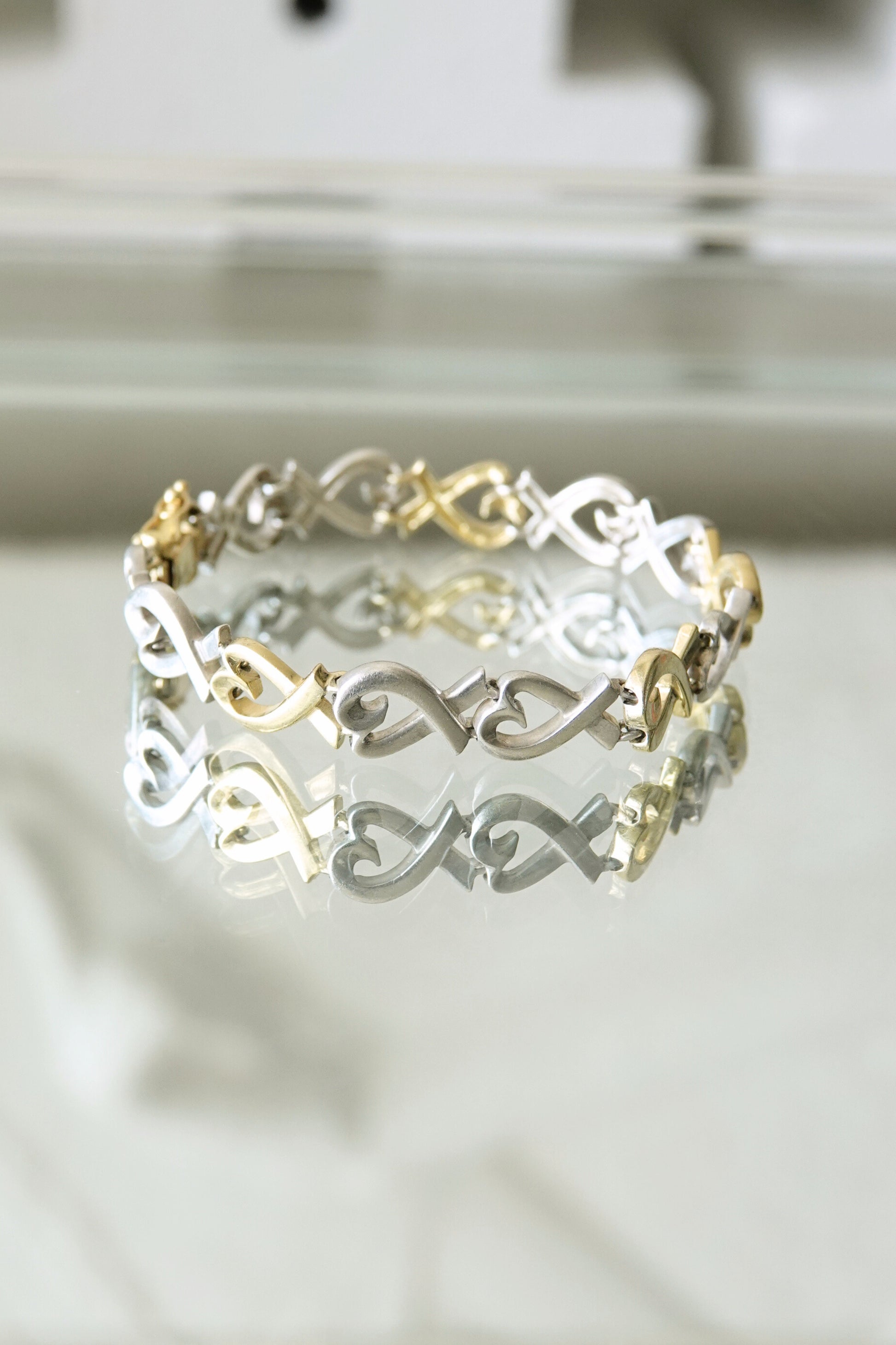 Paloma Picasso for Tiffany & Co. Loving Heart link bracelet: close-up detail of sterling silver and 18k gold heart-shaped links showing two-tone contrast and craftsmanship
