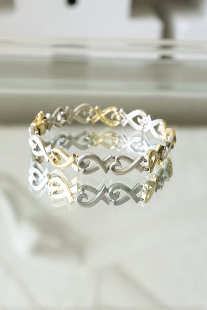 Paloma Picasso for Tiffany & Co. Loving Heart link bracelet: close-up detail of sterling silver and 18k gold heart-shaped links showing two-tone contrast and craftsmanship