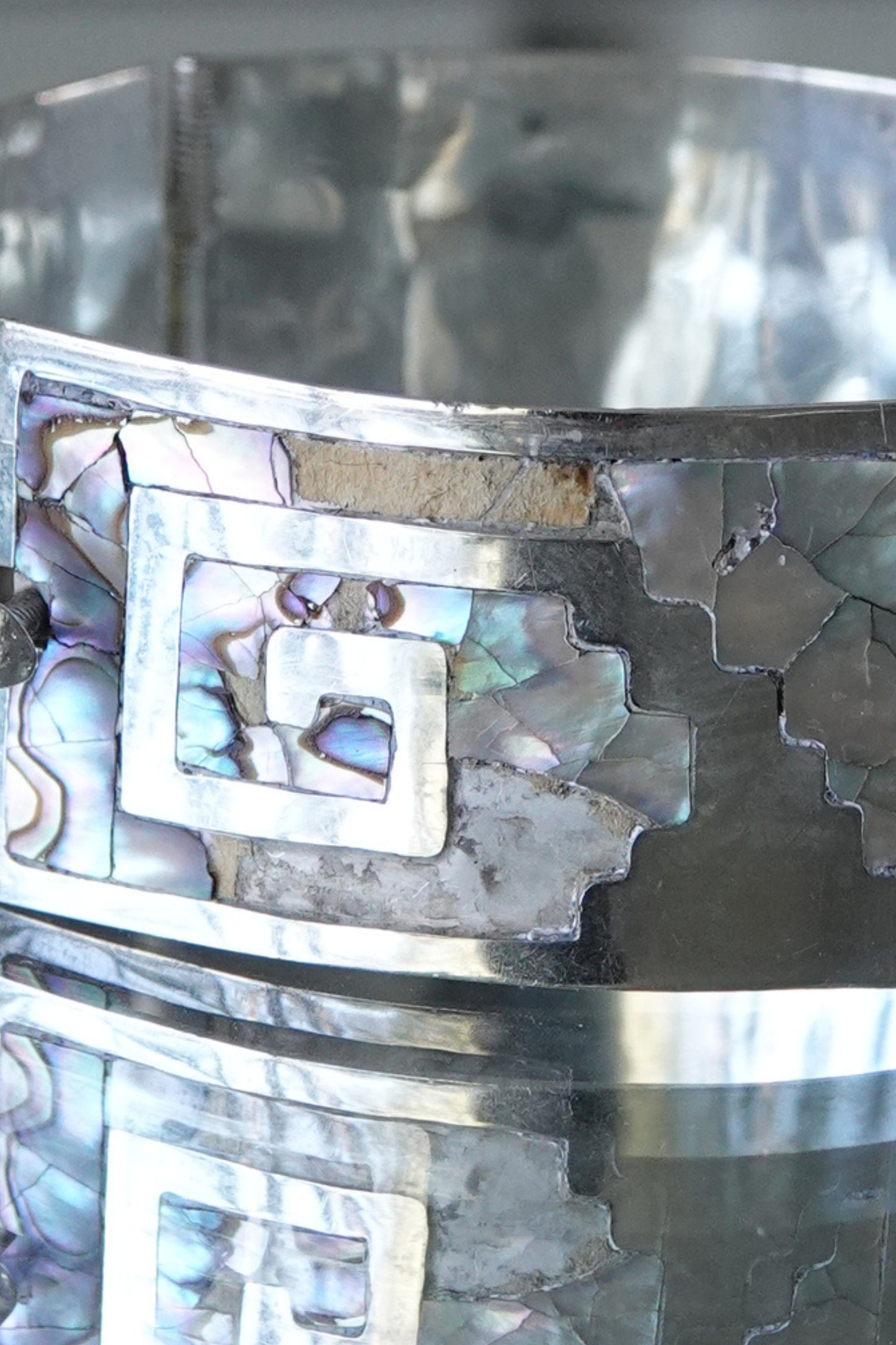 Close-up of Greek key cutout pattern with abalone mosaic inlay detail