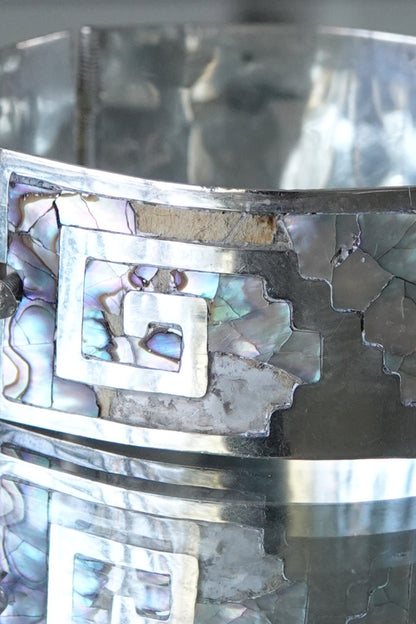Close-up of Greek key cutout pattern with abalone mosaic inlay detail