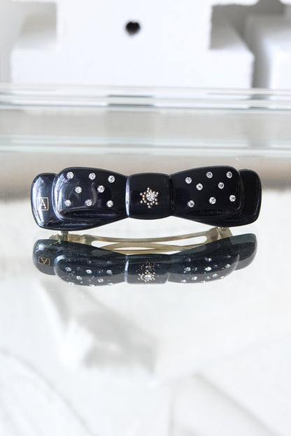 Alexandrine Paris rhinestone bow barrette, A logo visible — styled on reflective surface — Disco Palma