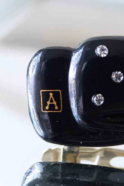 Alexandrine Paris A logo close-up — gold cartouche on black lacquer