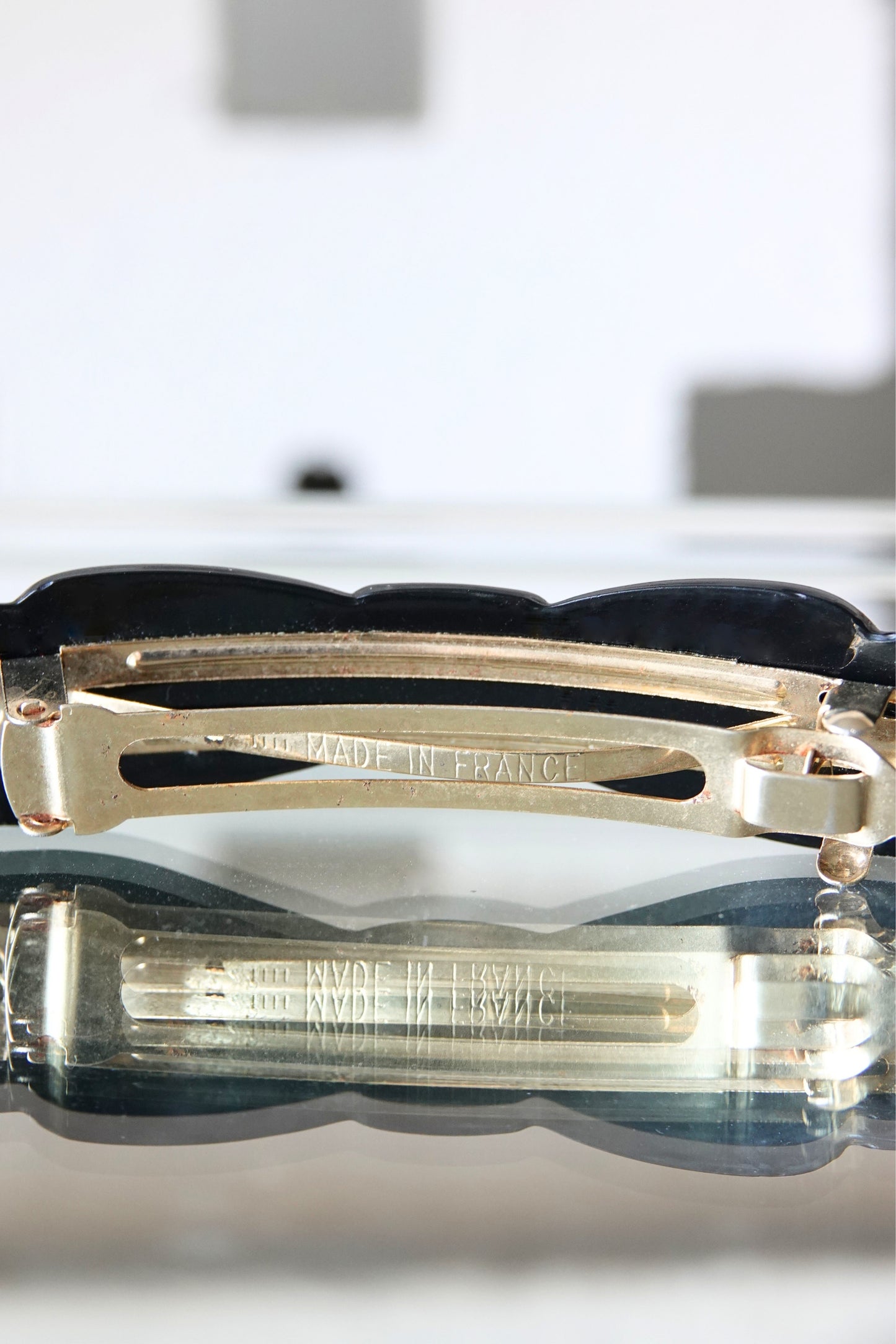 Alexandrine Paris barrette — side profile on glass surface