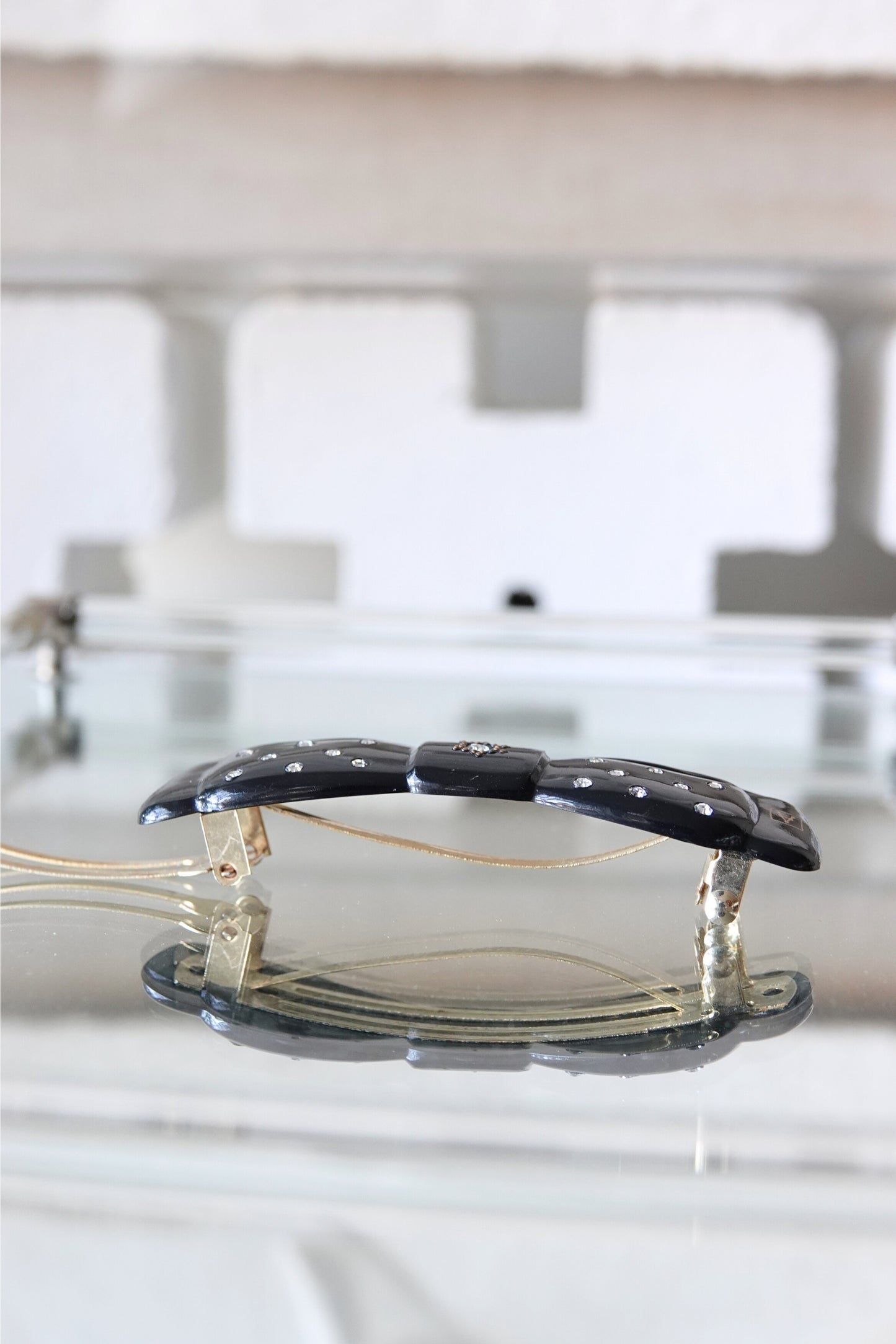 Black lacquer rhinestone barrette — angled view showing full bow shape