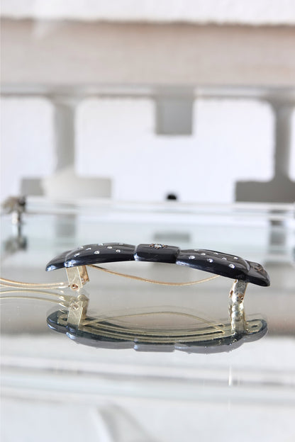 Black lacquer rhinestone barrette — angled view showing full bow shape