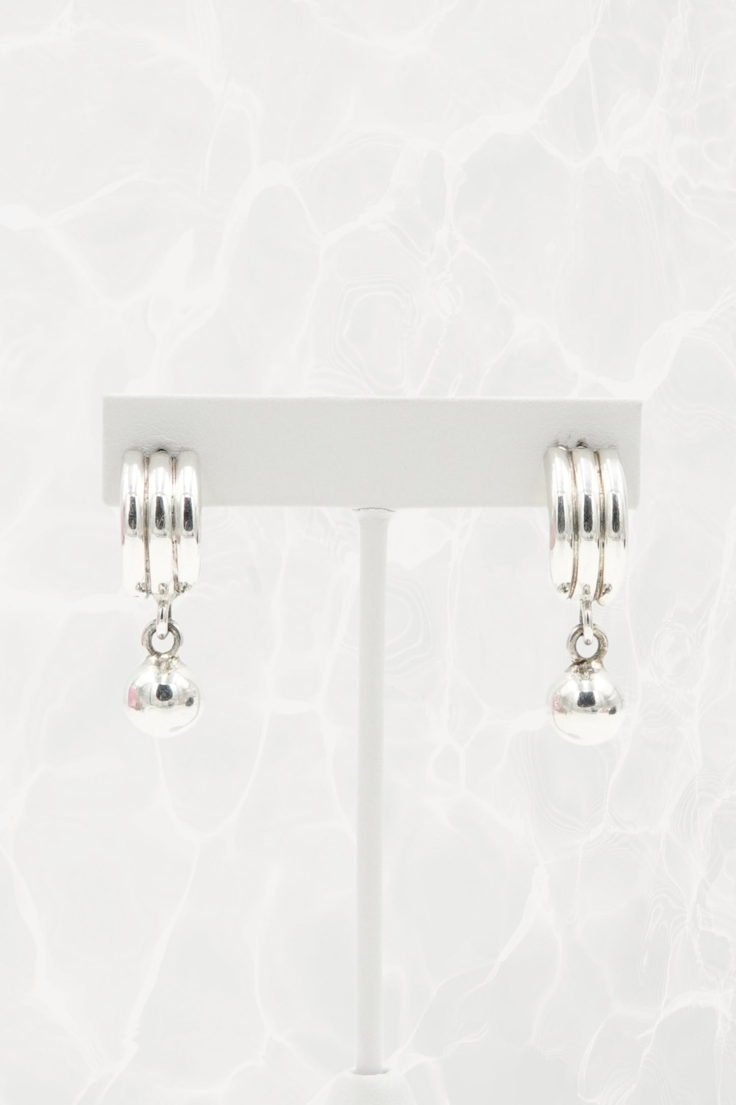 Sterling silver Mexican earrings — pair on earring stand, front view