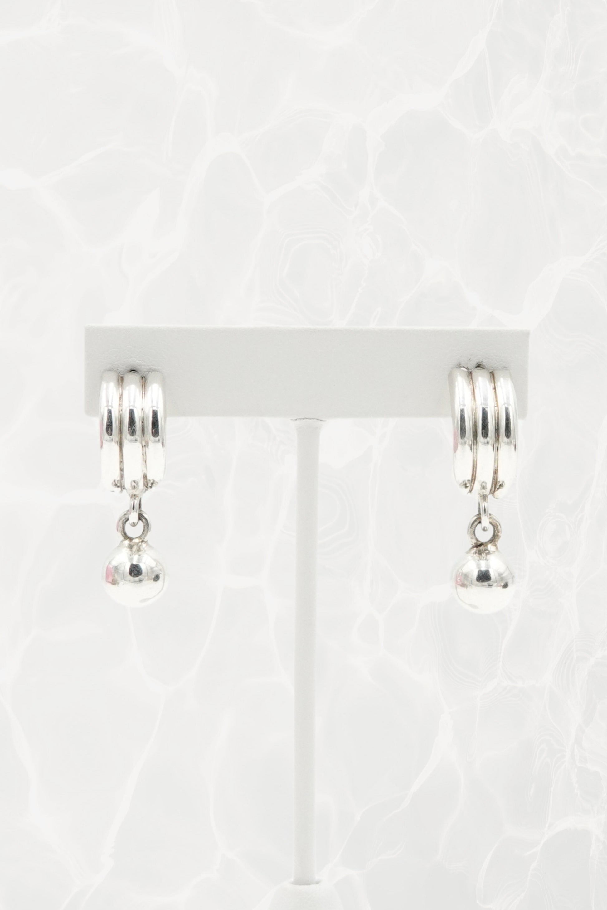 Sterling silver Mexican earrings — pair on earring stand, front view