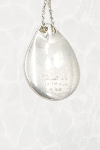 Elsa Peretti for Tiffany & Co. sterling silver Madonna pendant necklace: overhead flat lay view showing full chain and pendant together on neutral surface