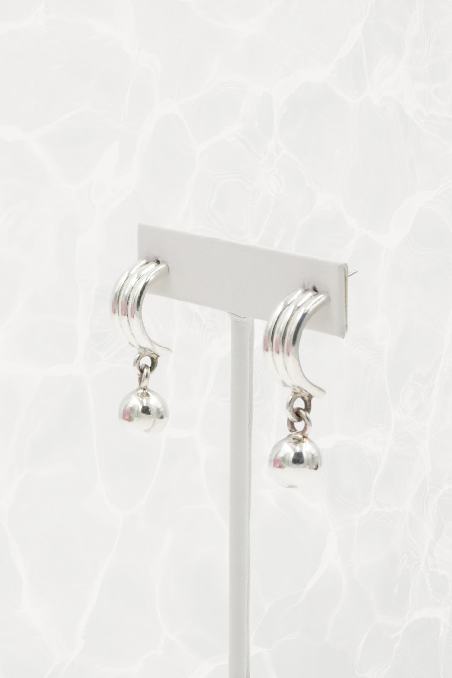 Sterling silver crescent earrings — close-up of ribbed top and ball dangle