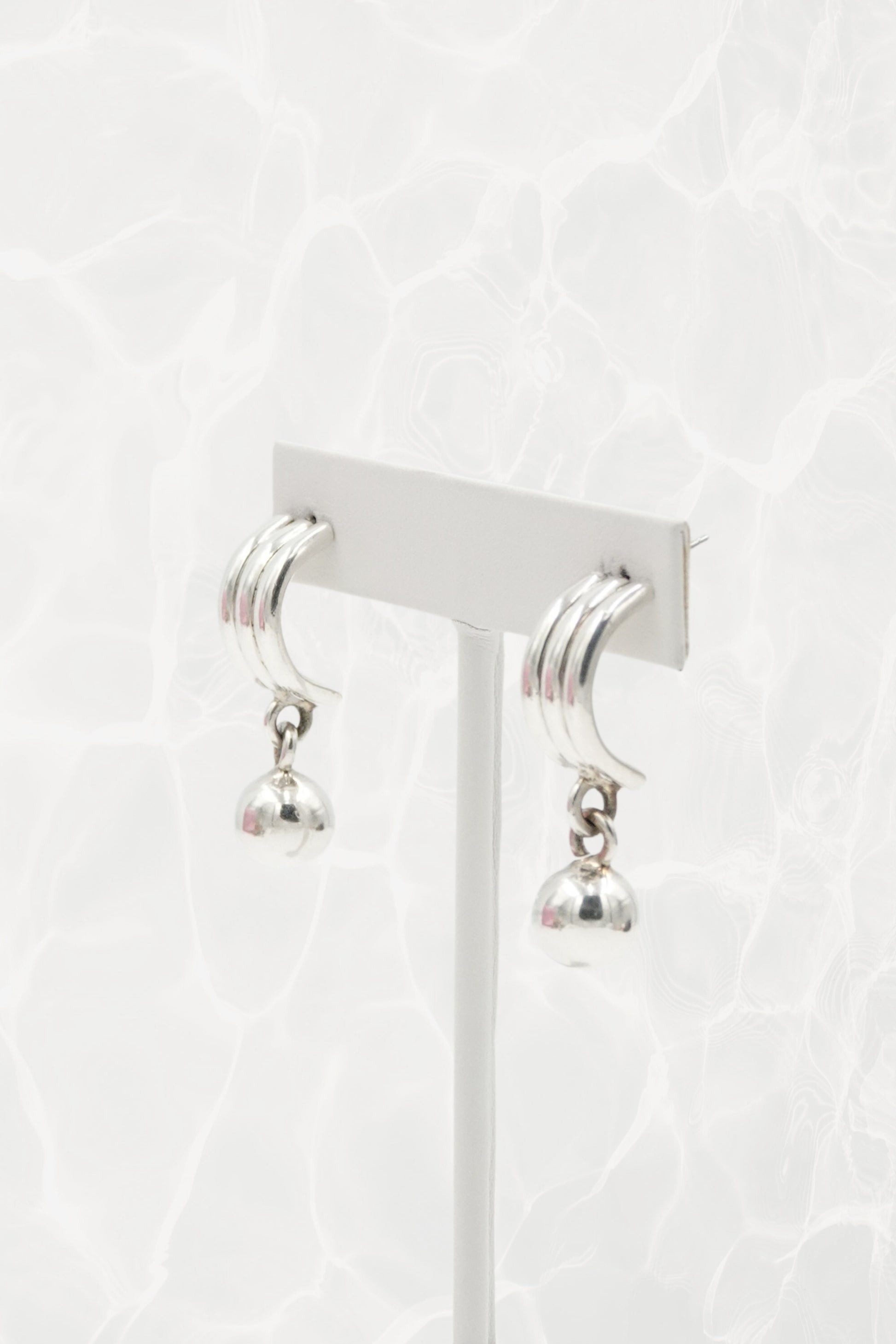 Sterling silver crescent earrings — close-up of ribbed top and ball dangle