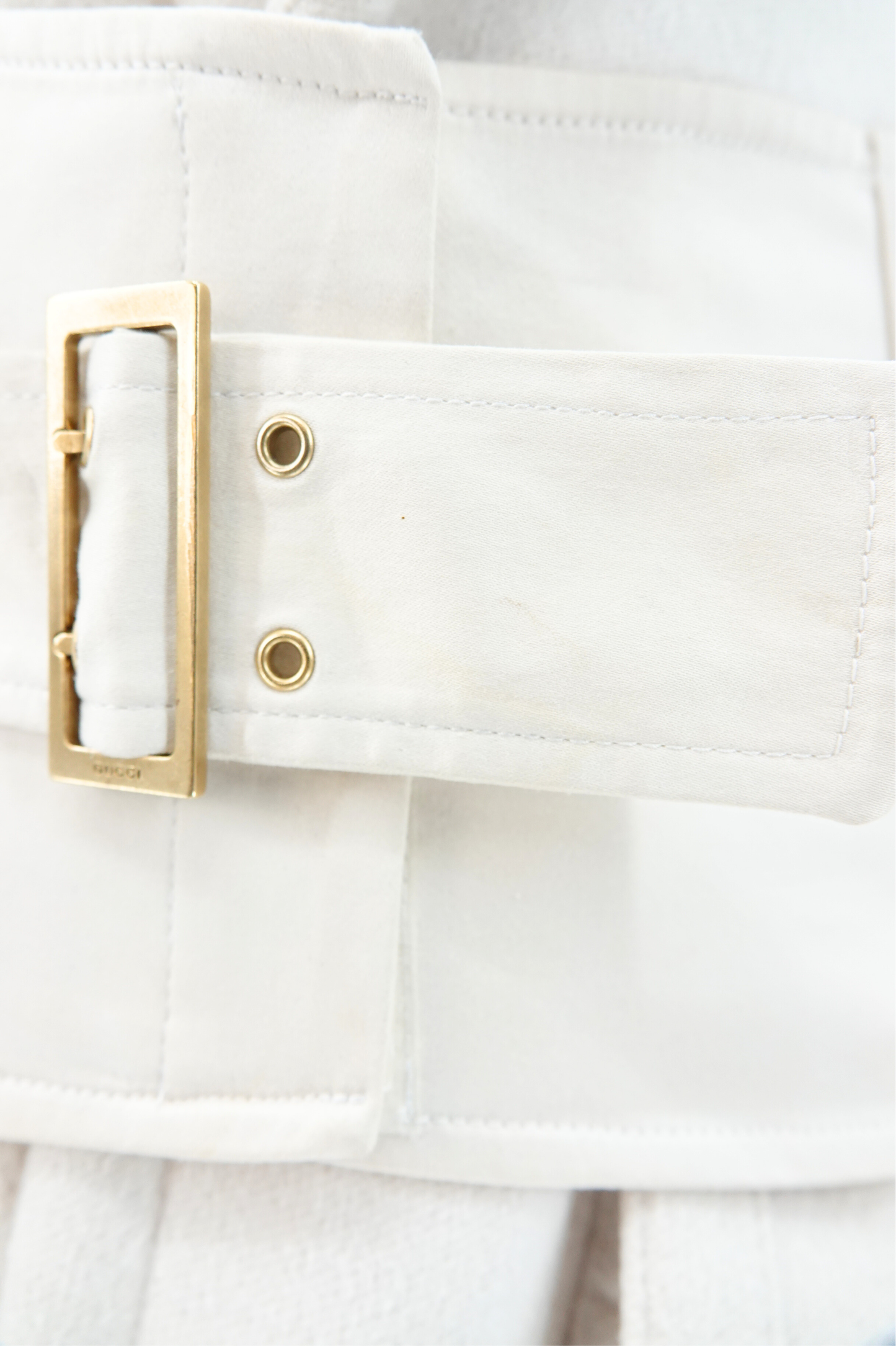 Tom Ford for Gucci AW03 white wool angora coat hardware detail: extreme close-up of gold-tone rectangular buckle on detachable corset belt with brass stud eyelets, Fall Winter 2003